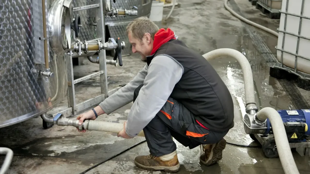 mężczyzna ze zbiornikami przemysłowymi